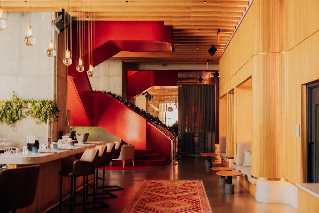 Lobby di un hotel con scala rossa scultorea e pareti in legno